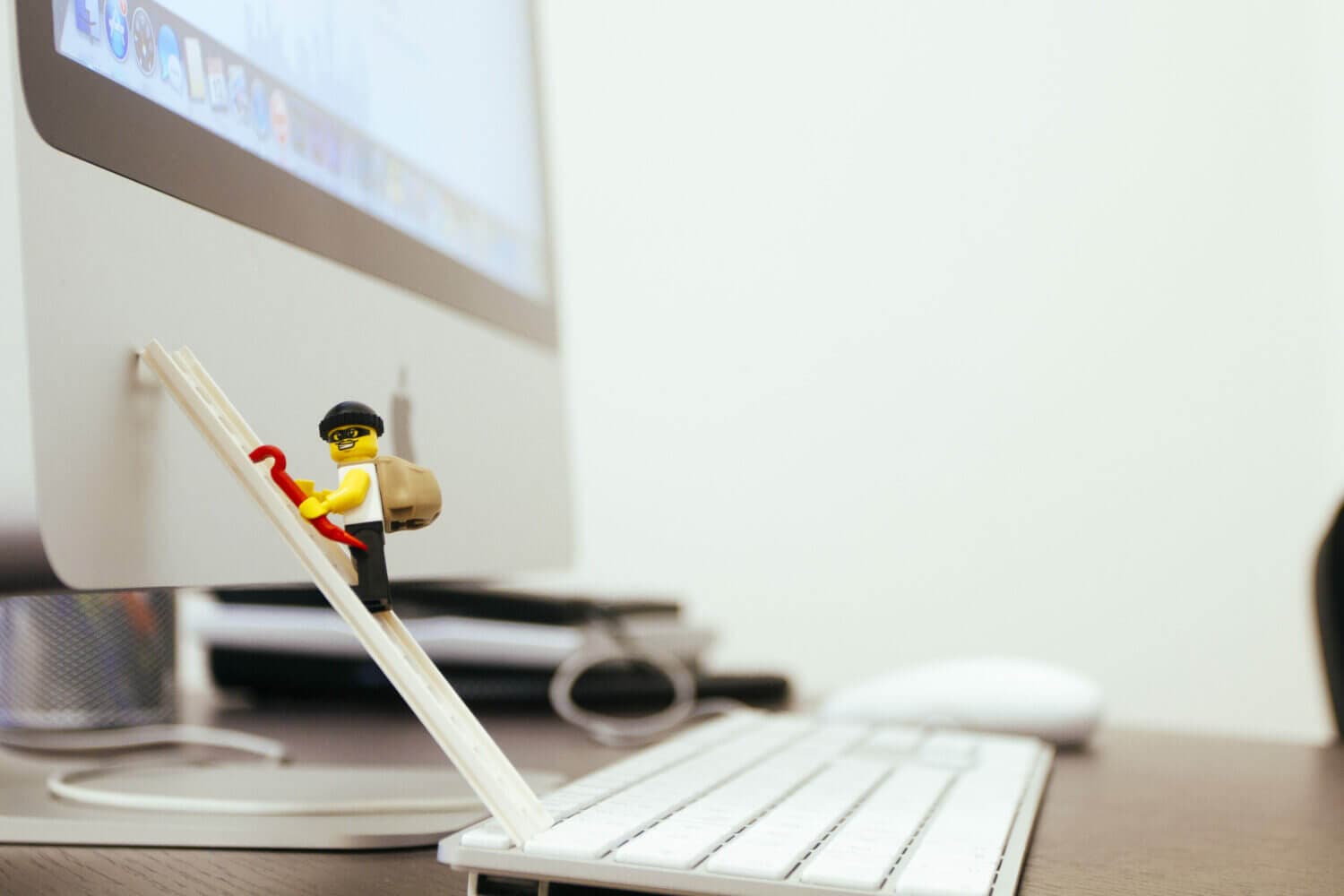 lego man climbing a ladder on an Apple computer