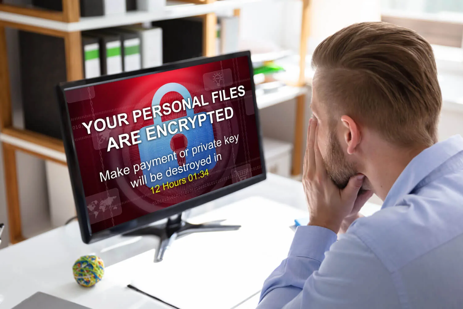 hacked business with ransomware and encrypted files man looking at computer screen